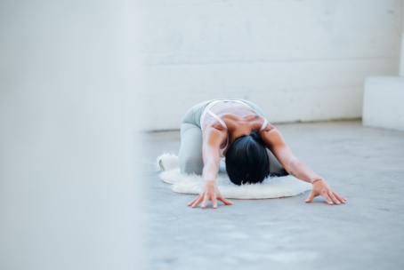 Bee Bosnak doing yoga in a white yoga studio