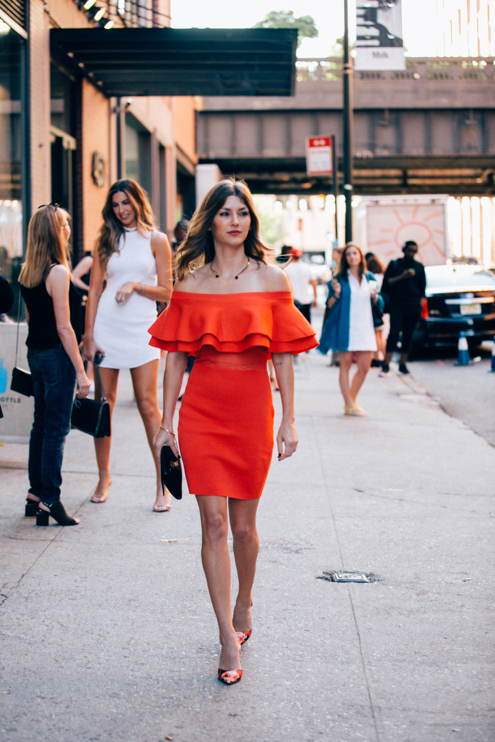 a girl in a red dress walking down the street